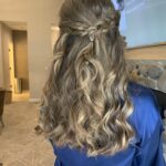 bridesmaid wearing half up half down curled hairstyle with thick braid accent