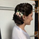 floral hairpin accent added to elegant updo hairstyle with braid